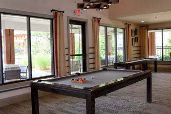 A game room with a pool table and a ping pong table